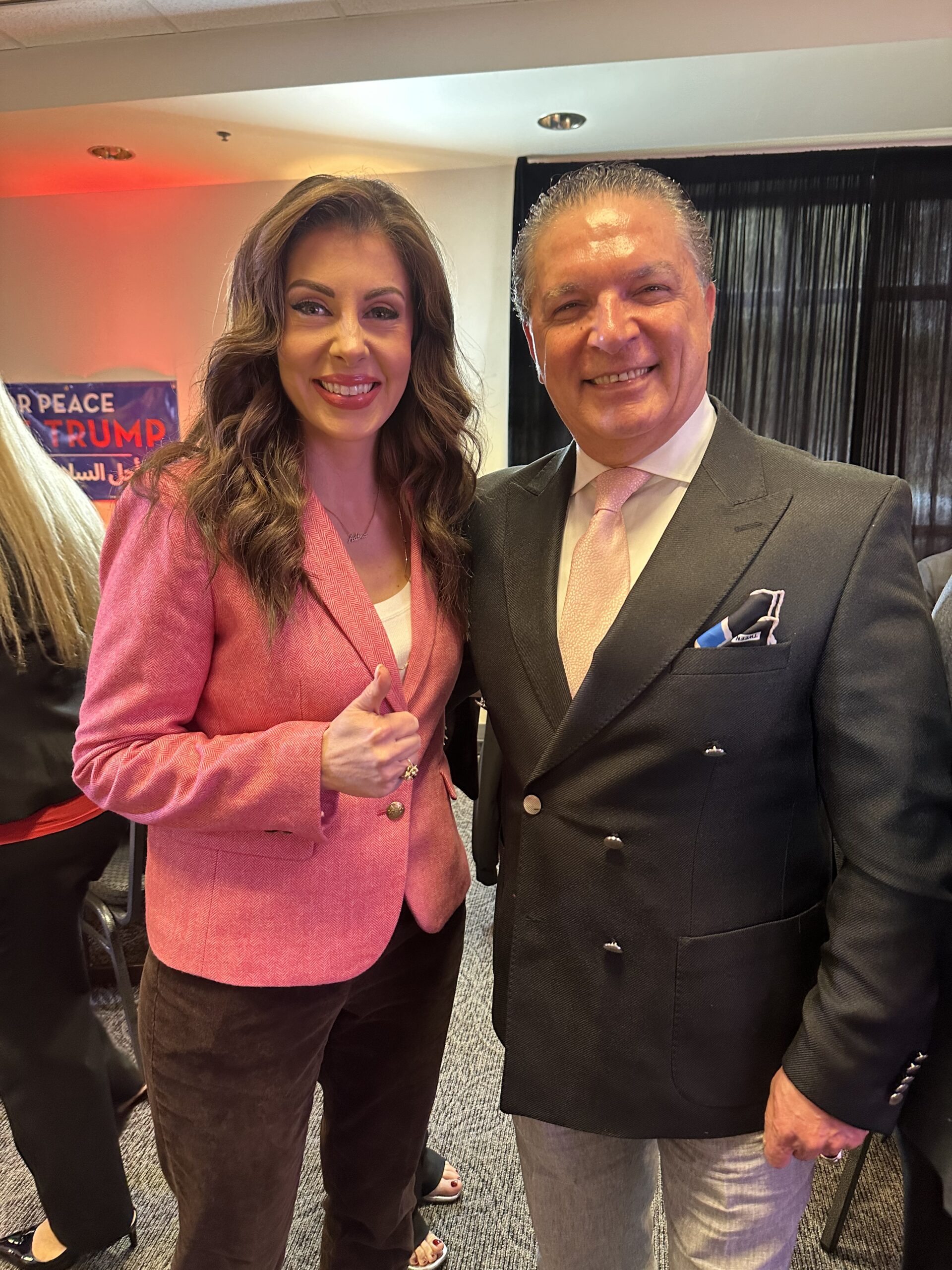 Two smiling individuals pose together at an event